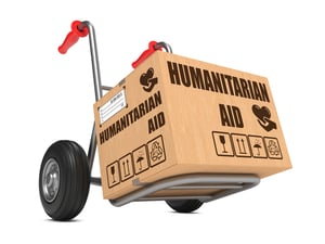 Humanitarian Aid Slogan on Cardboard Box on Hand Truck White Background
