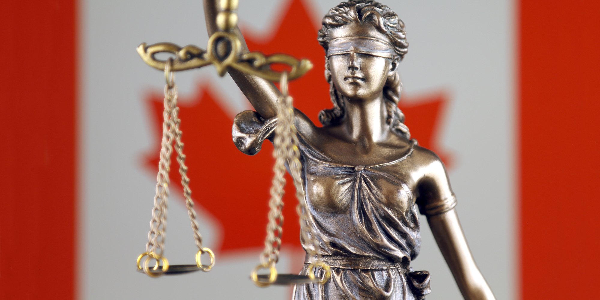 justice scales statue and Canadian flag