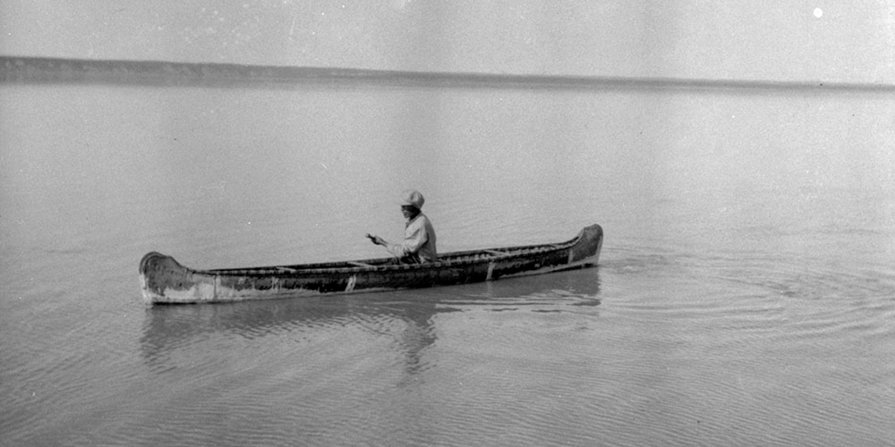 Dene man in a birch bark canoe