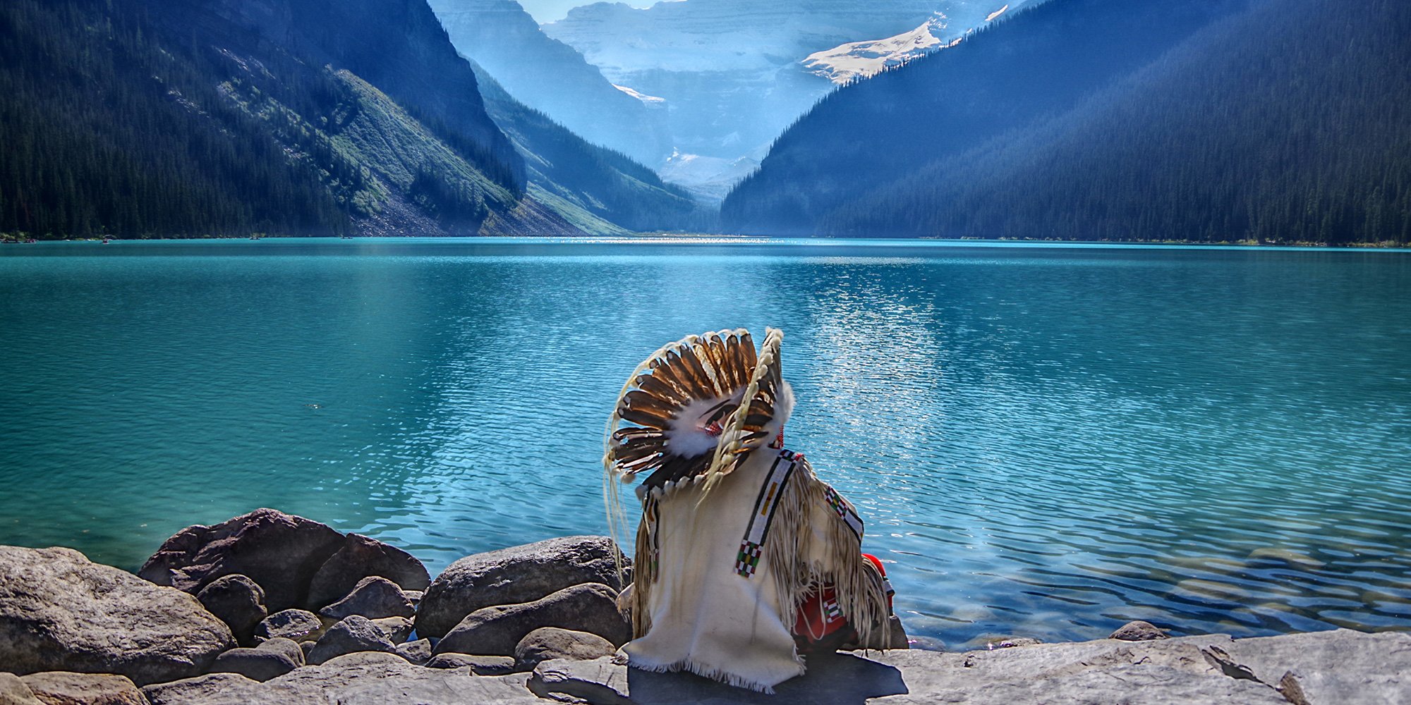 man in headdress by lake