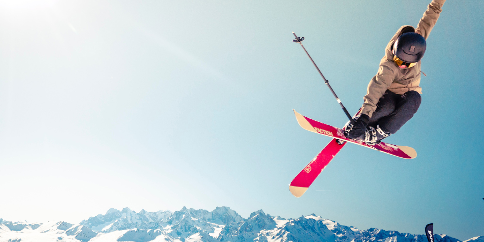 skier jumping with mountains behind